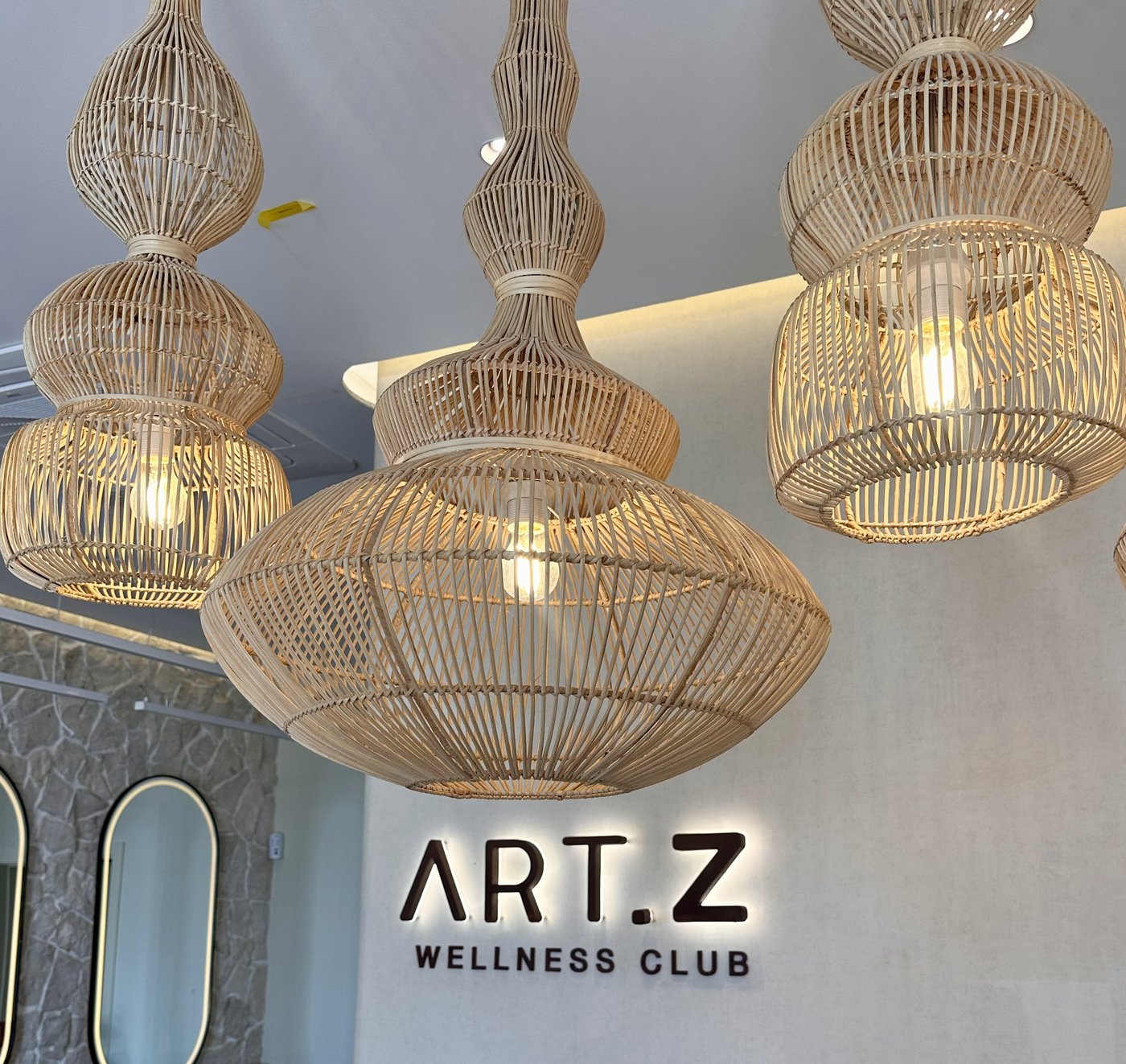Rattan pendant lights and the ART.Z Wellness Club sign, in Estoril
